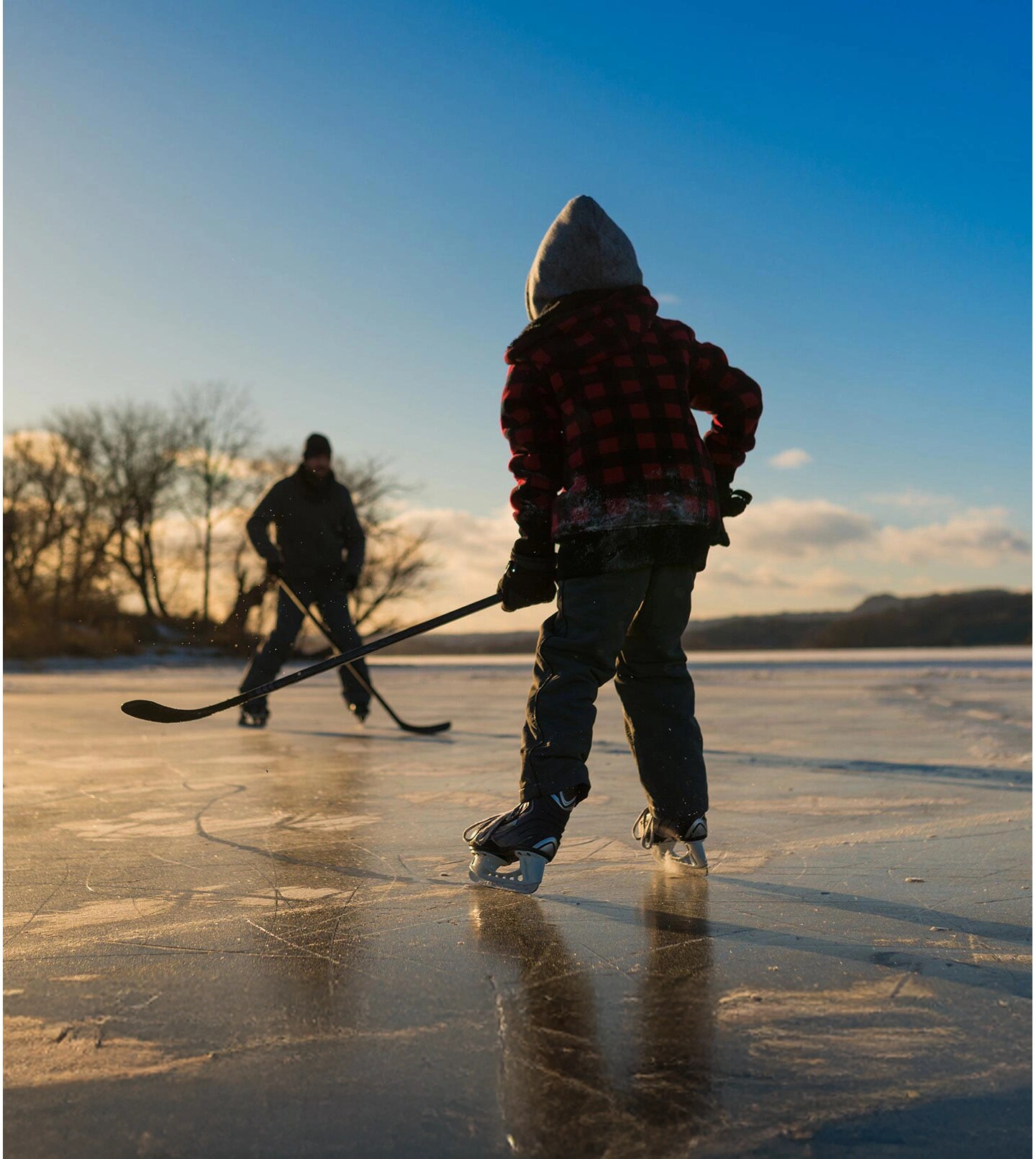 Two kids play ice hockey.