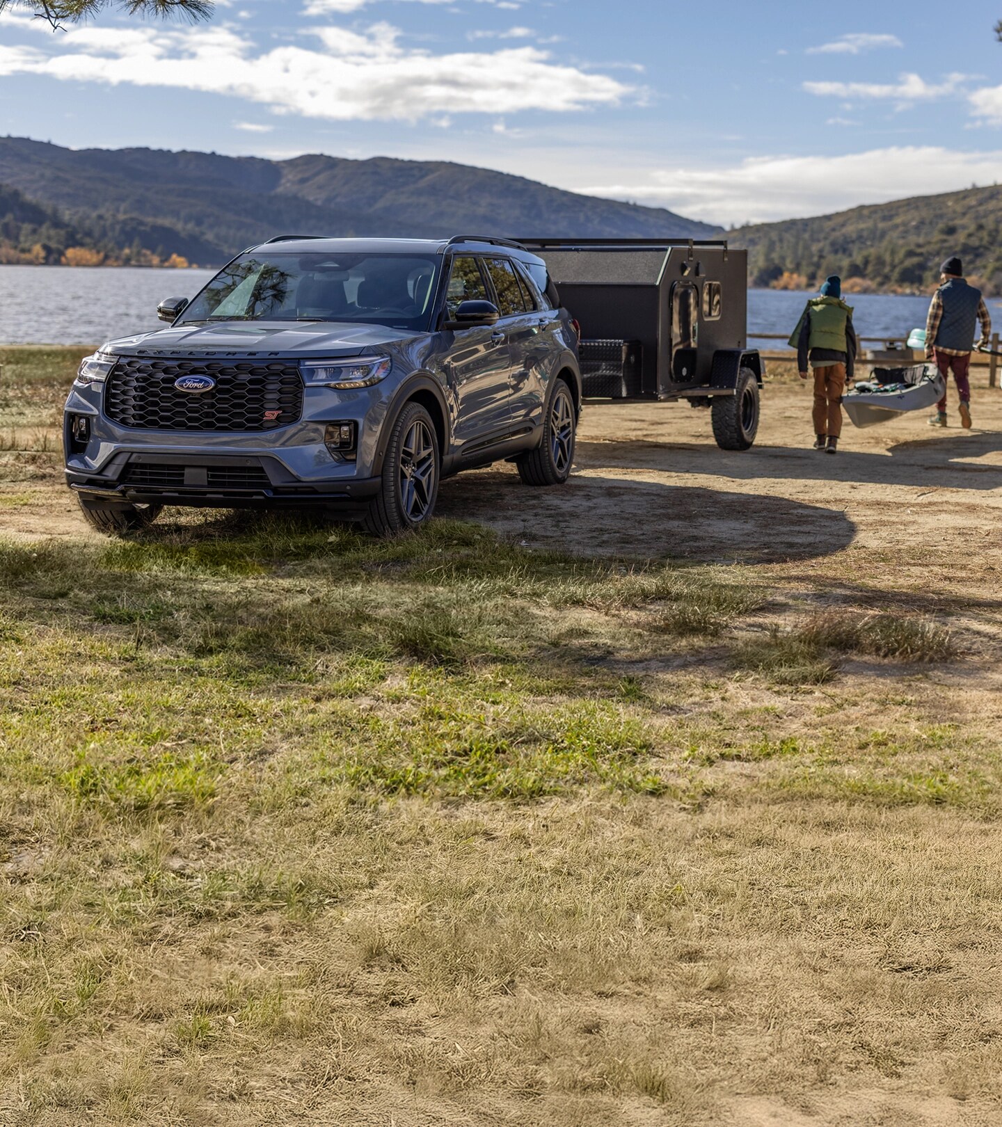 Ford Explorer with attached trailer parked by a lake.