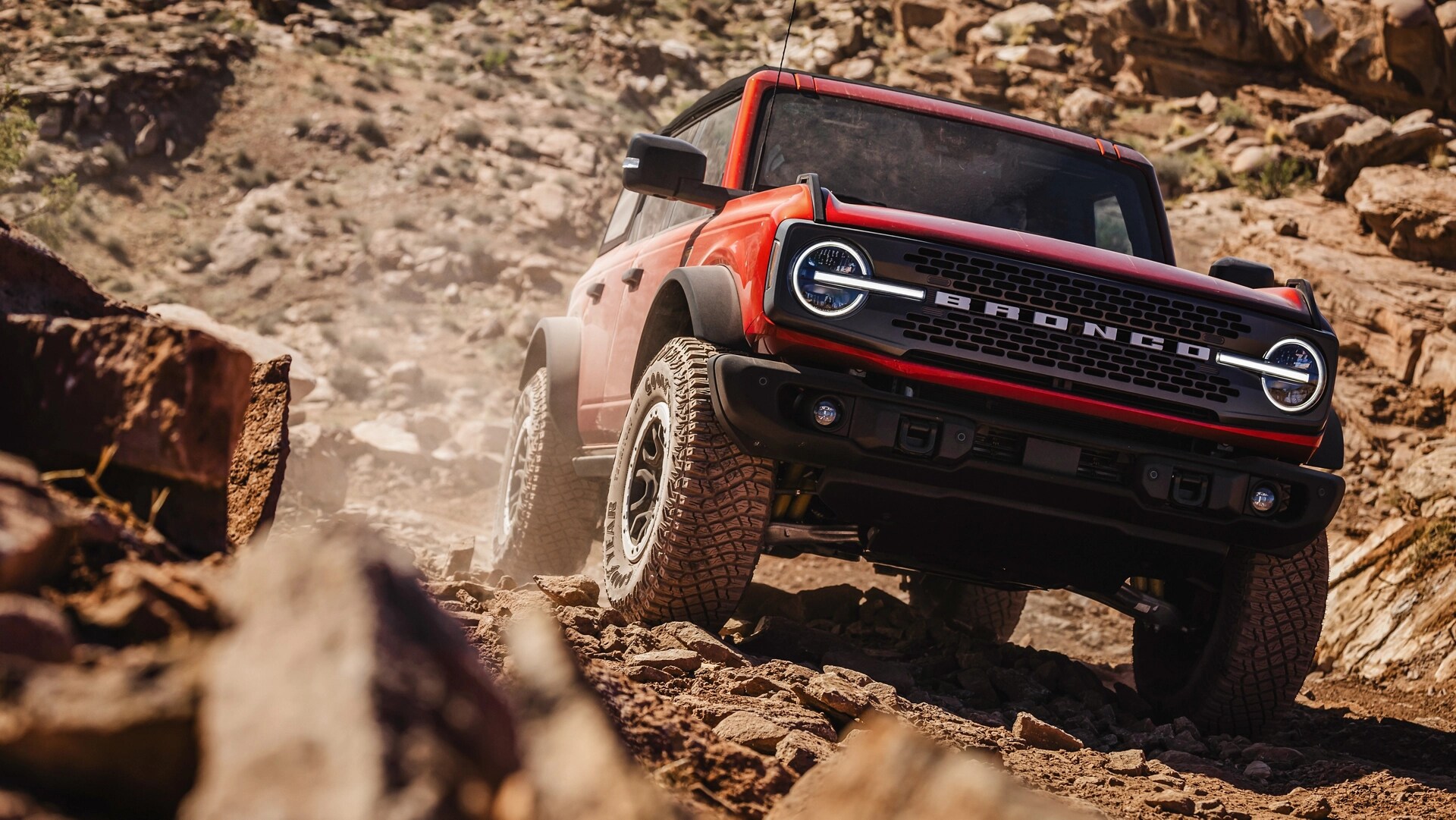 A 2025 Ford Bronco® SUV driving on a muddy hillside