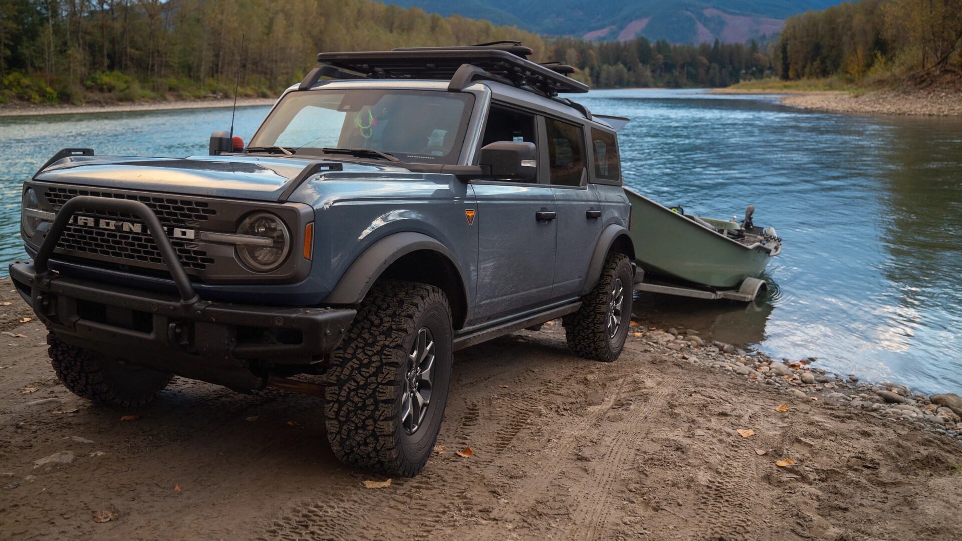 A 2025 Ford Bronco® SUV backing a boat trailer into a mountain lake