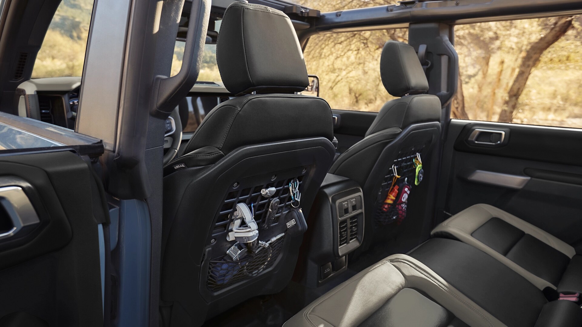 The backseat area of a 2025 Ford Bronco® SUV, showing the MOLLE panels integrated into the backs of the front seats
