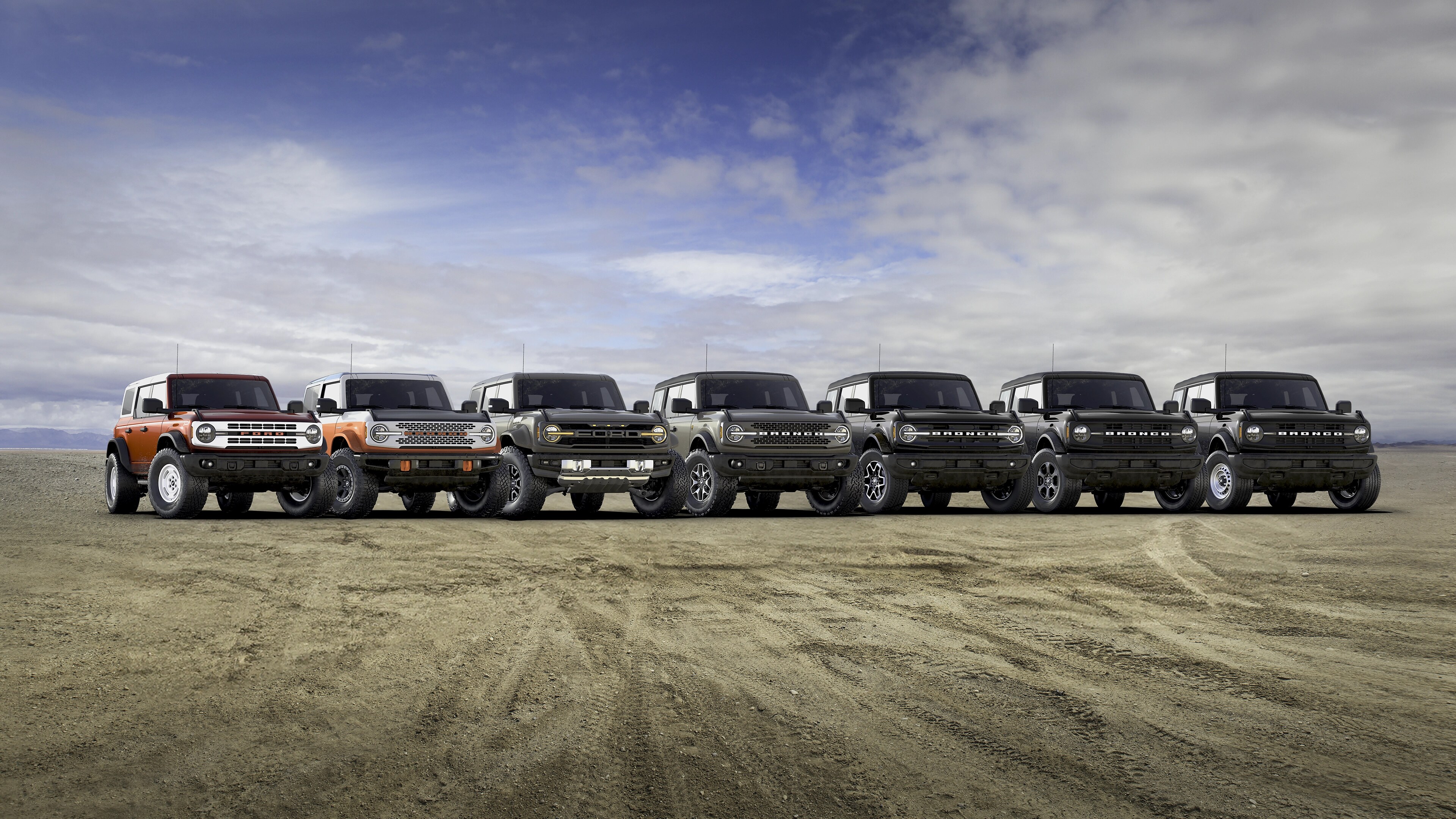 The seven 2025 Ford Bronco® models lined up next to each other on a mud flat