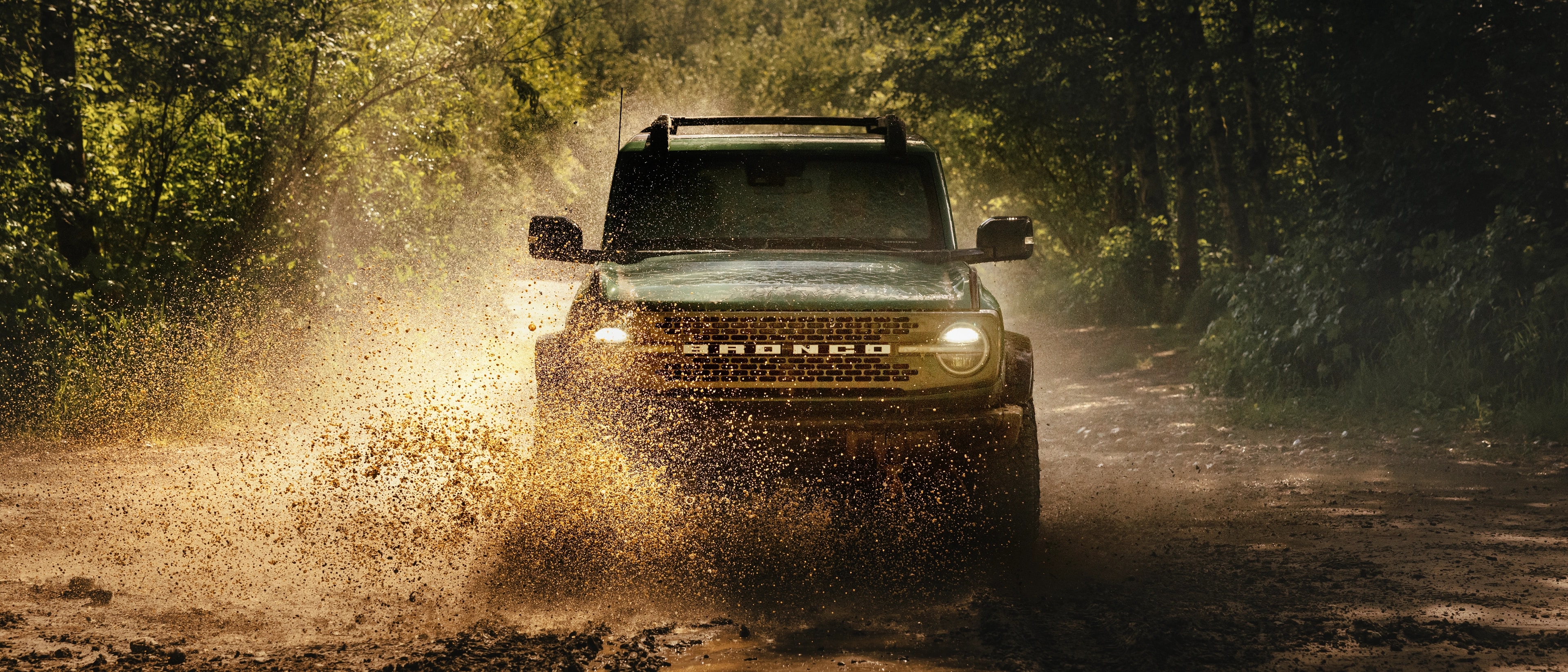 A 2025 Ford Bronco® SUV fording a stream in the woods