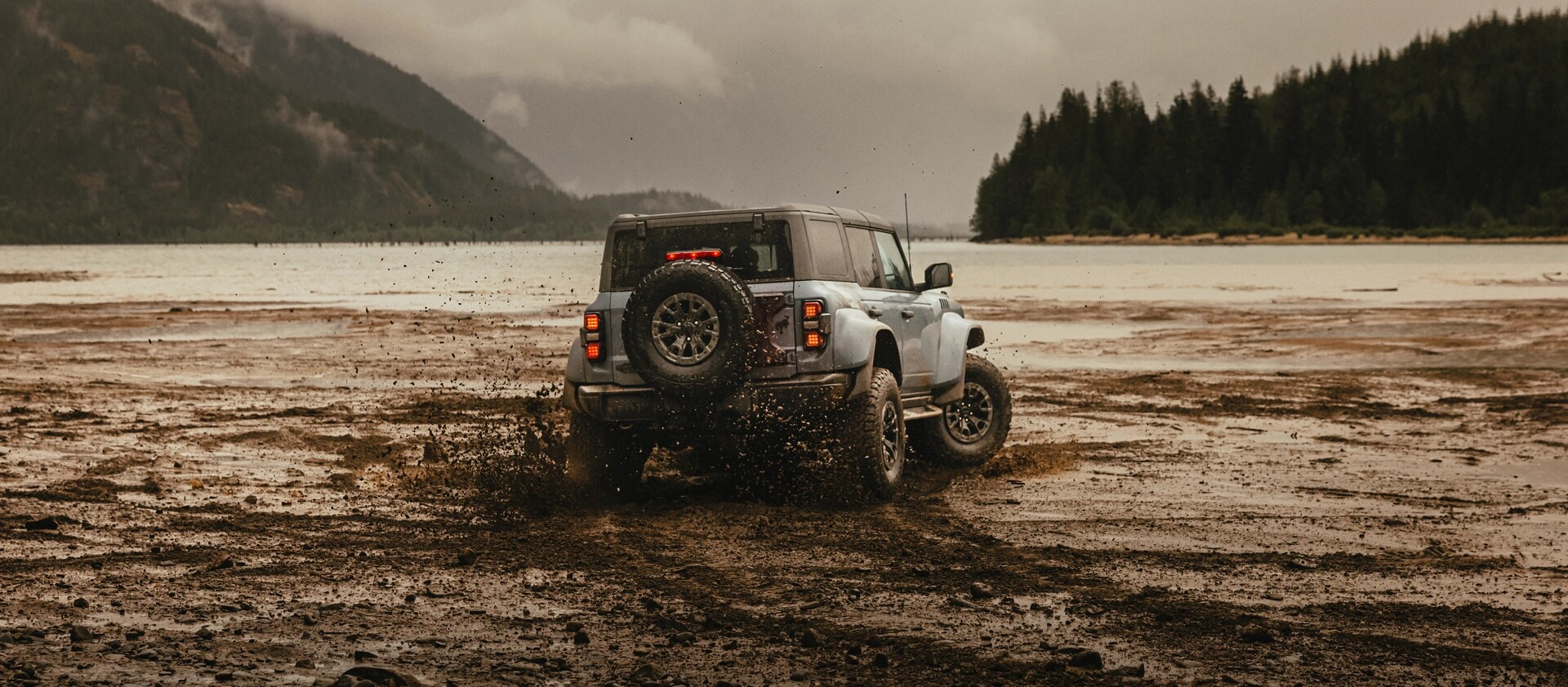 A 2025 Ford Bronco® SUV leaving tire tracks on a mud flat in a valley
