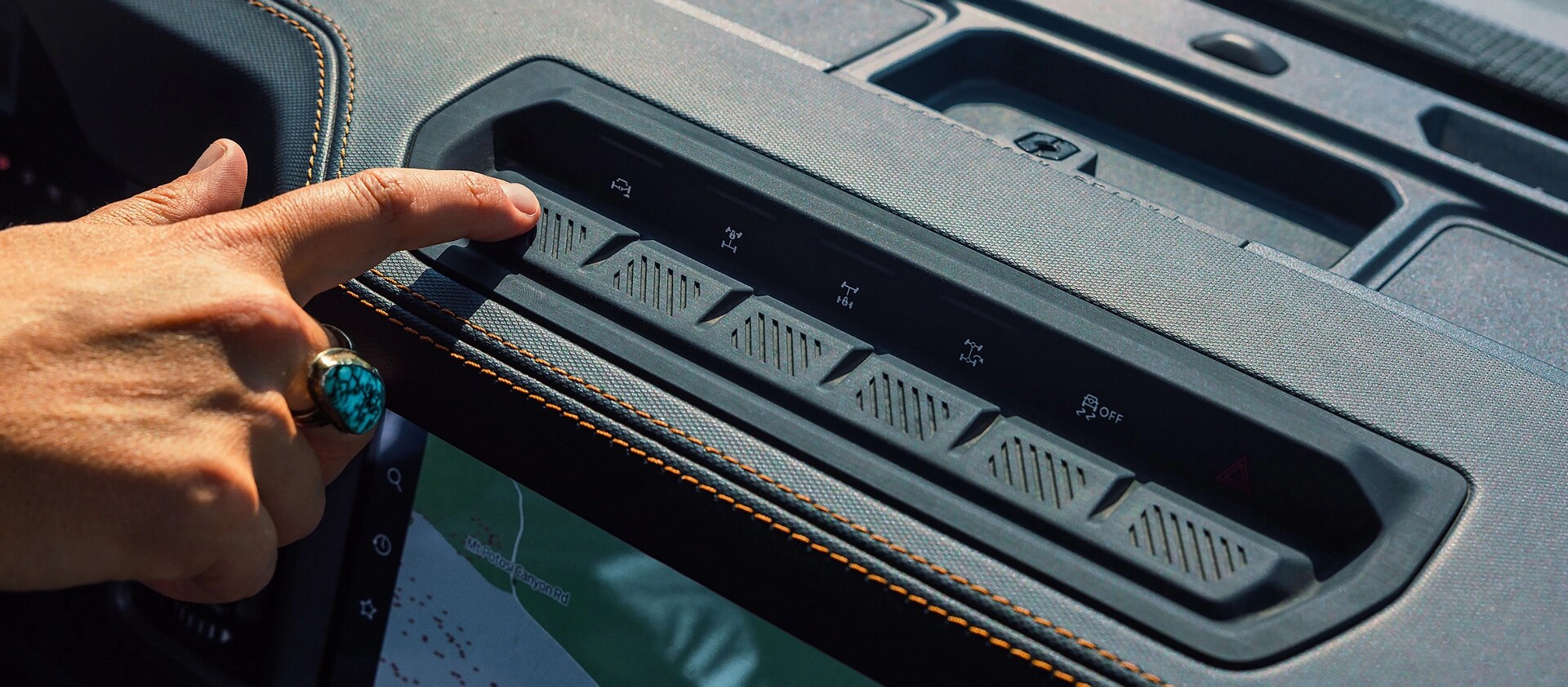 A finger pressing one of the auxiliary hero switches on a 2026 Ford Bronco® SUV