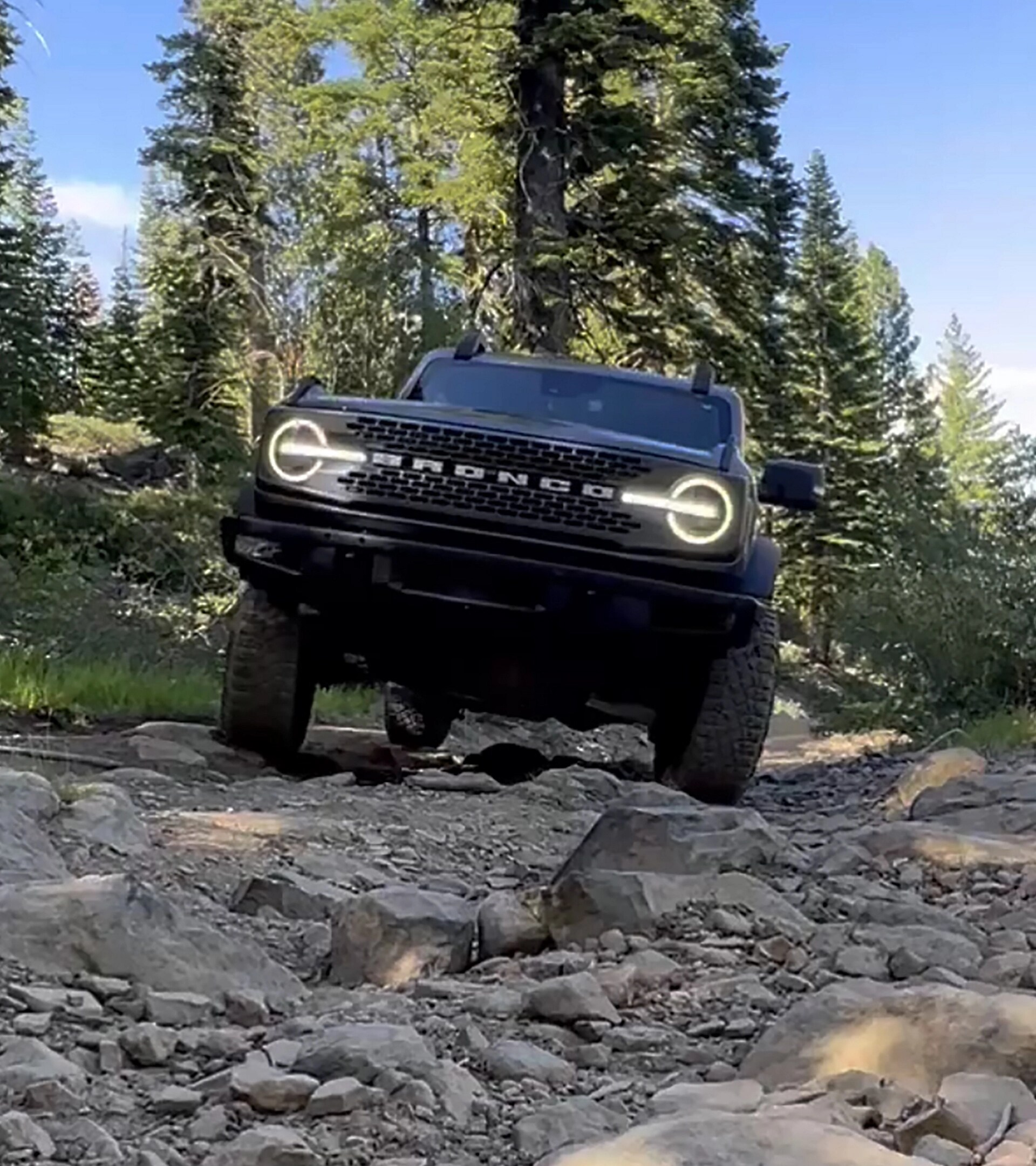 A 2026 Ford Bronco® SUV being driven over rocks and boulders in a dry riverbed