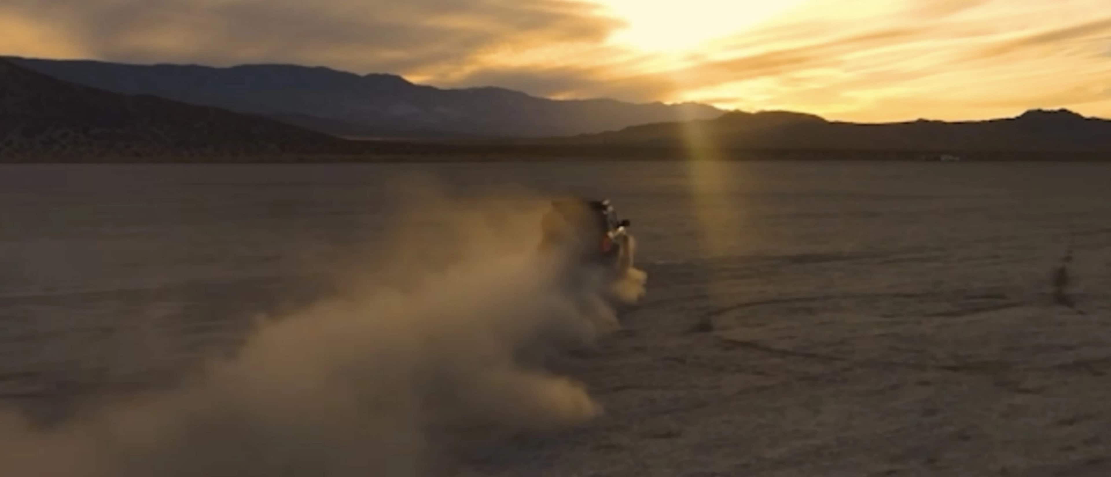 A 2026 Ford Bronco® SUV being driven in a dusty desert at sunset