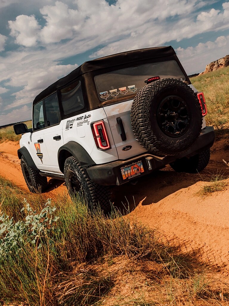 A 2026 Ford Bronco® SUV being driven on a dirt path in Moab, Utah