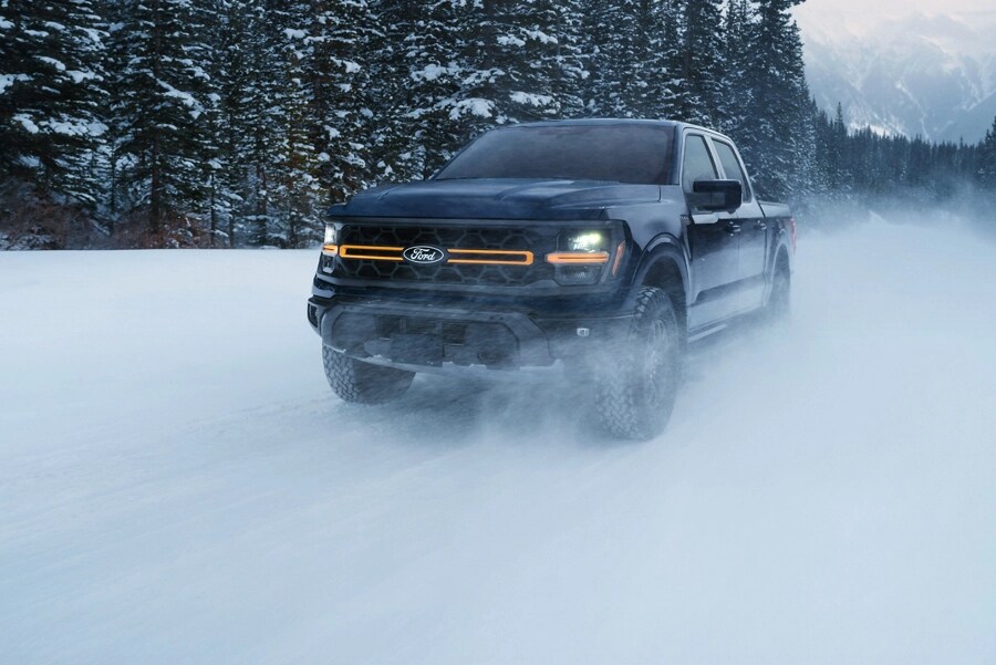 Front view of an F-150 Tremor driving on a snowy mountain road.