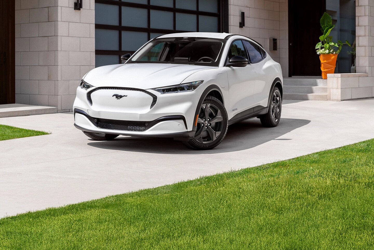 White Mach-E parked in a driveway.