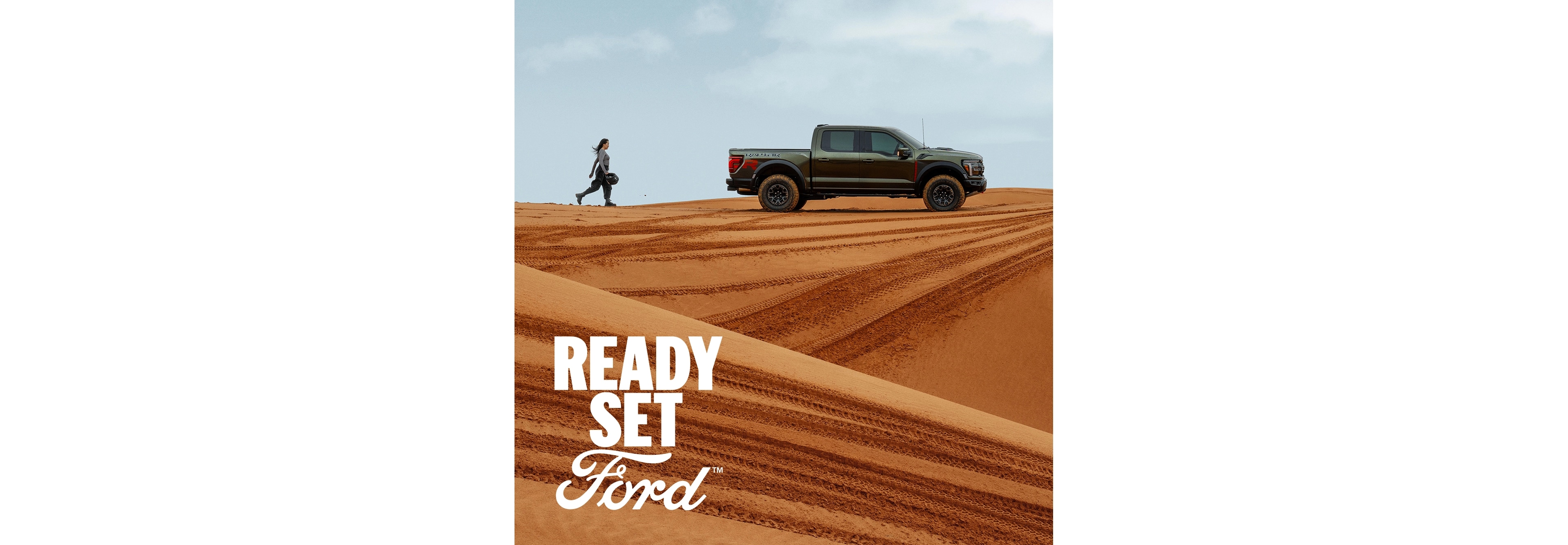 An F-150 in a desert landscape with Ready Set Ford Logo. 