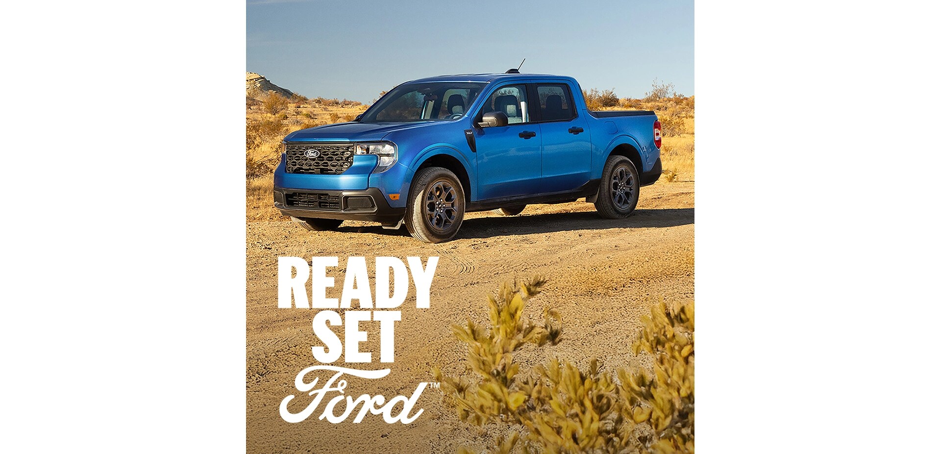 Three-quarter front view of a blue Ford Maverick parked on a dirt road in a desert. White text “Ready Set Ford” appears in the lower-left corner. 
