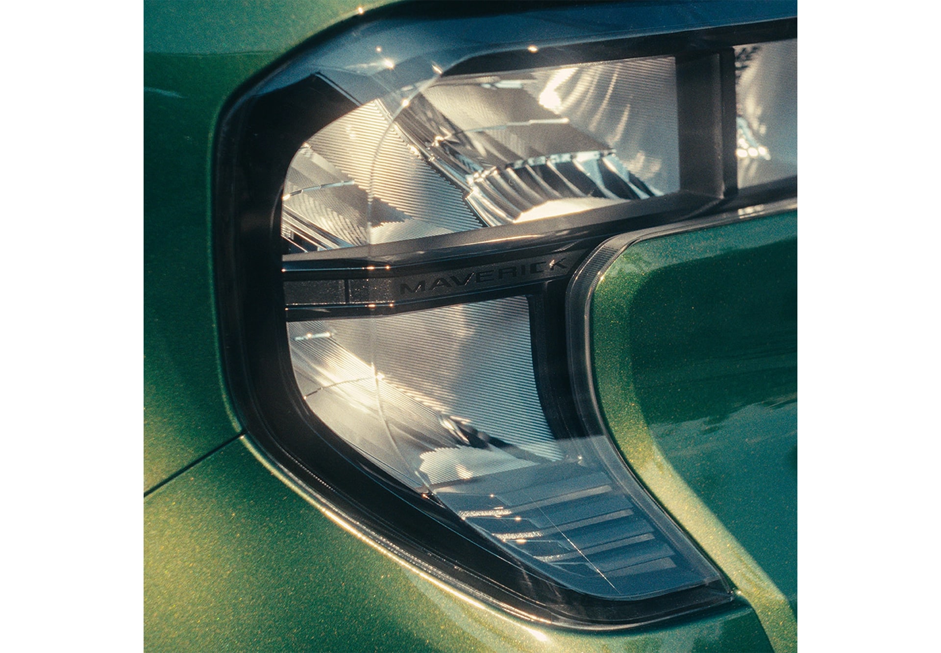 Close-up of a green Ford Maverick’s headlight. 