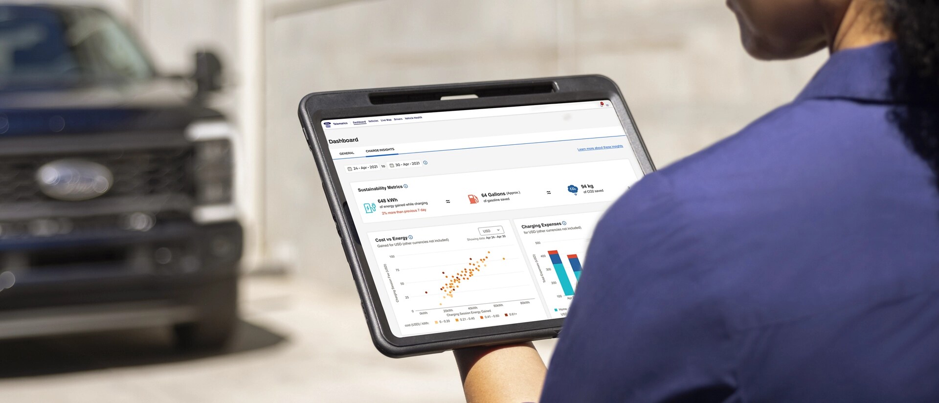 Worker using a tablet while a 2026 Ford Super Duty® Chassis Cab is blurred in the background