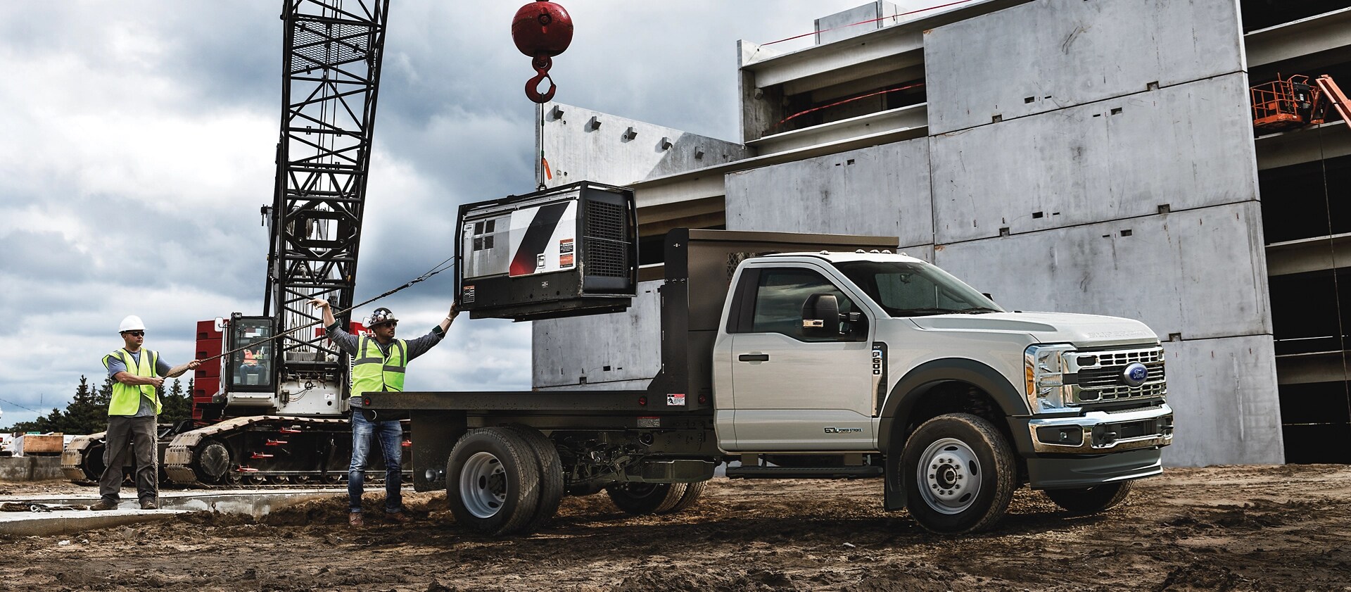 A 2026 Ford Super Duty® Chassis Cab parked on a construction site while something is being loaded onto the flatbed