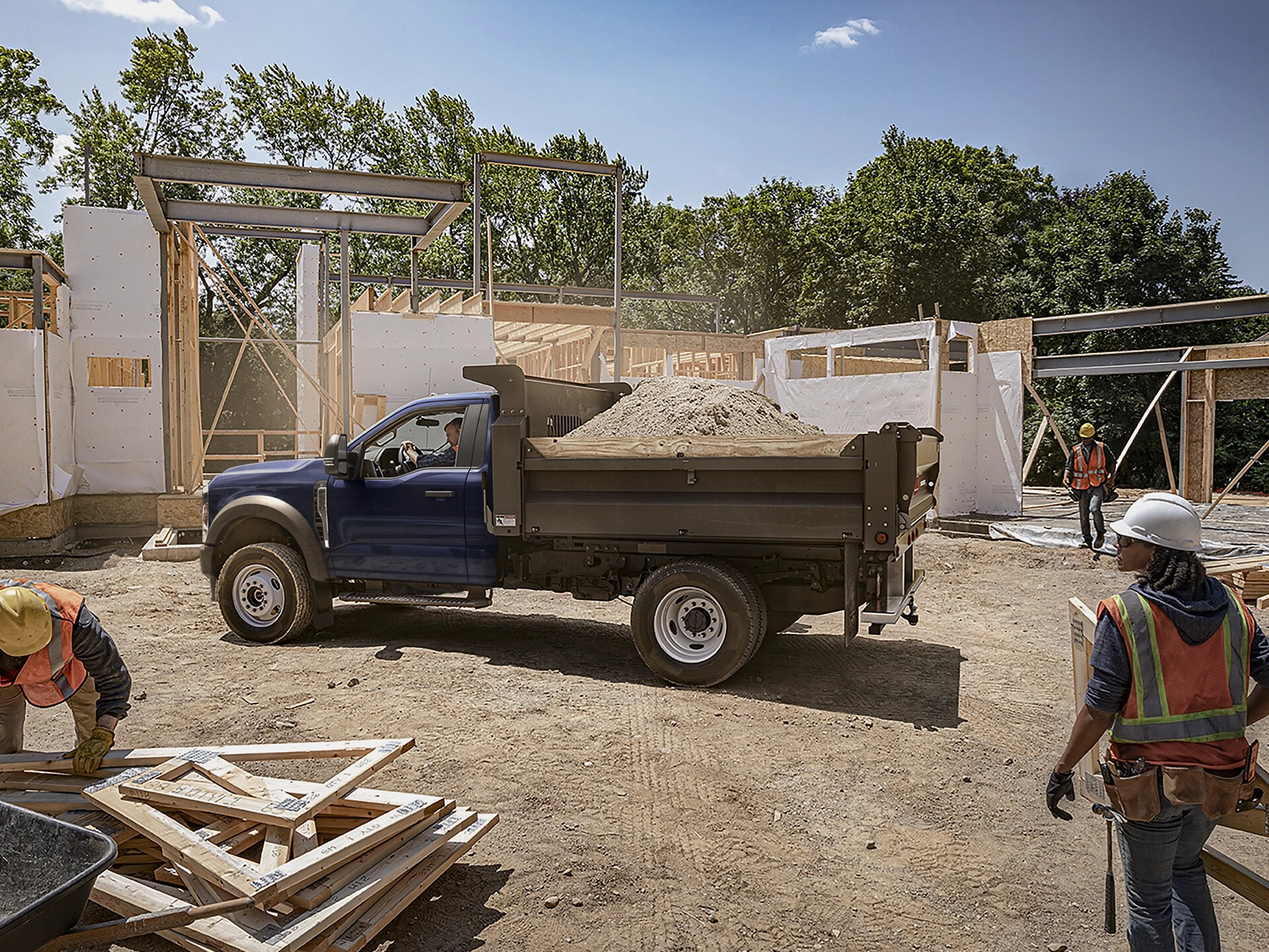 A 2026 Ford Super Duty® Chassis Cab with dump truck upfit loaded with dirt on a jobsite