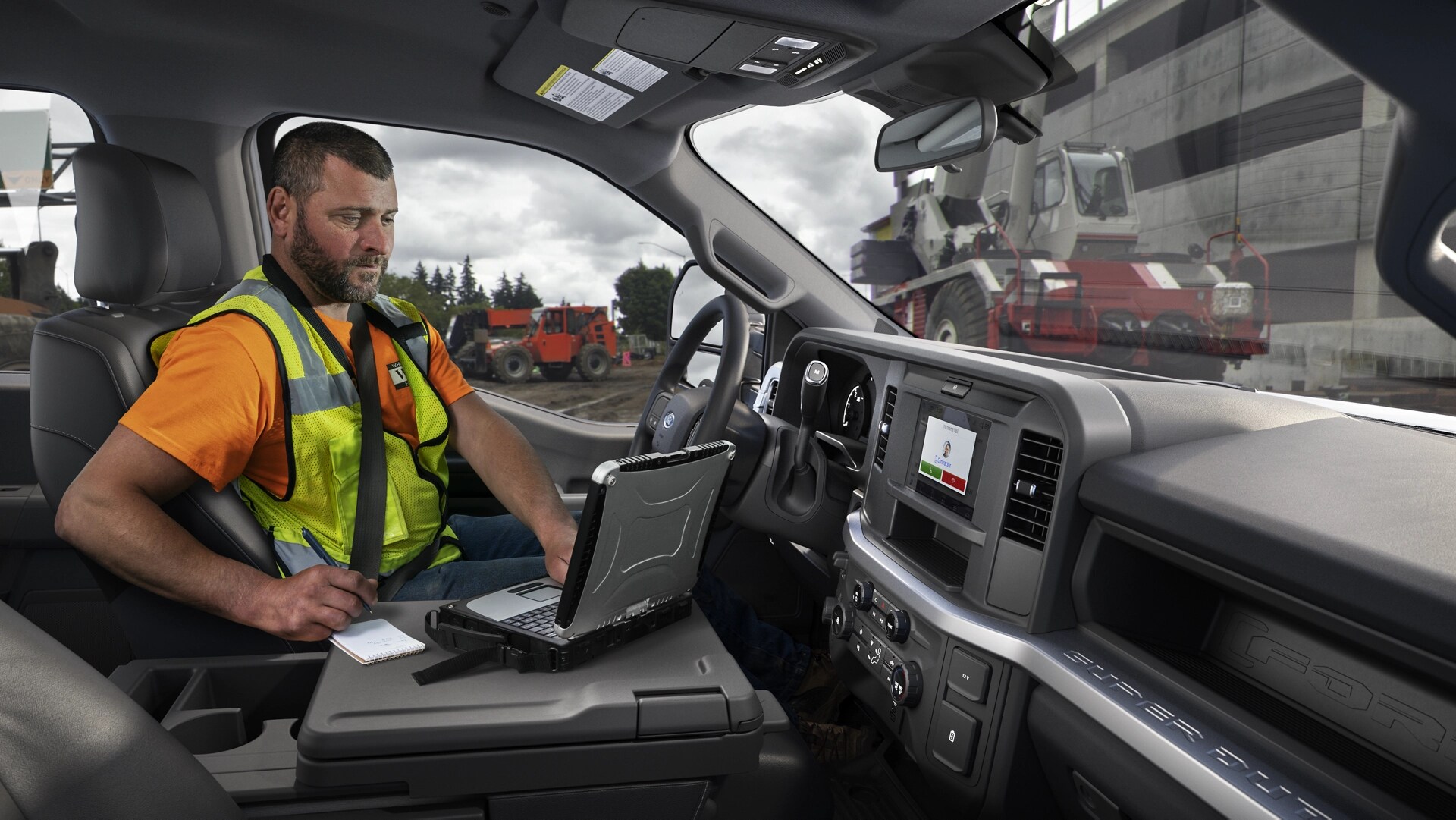 A worker using their computer on the center console interior work surface
