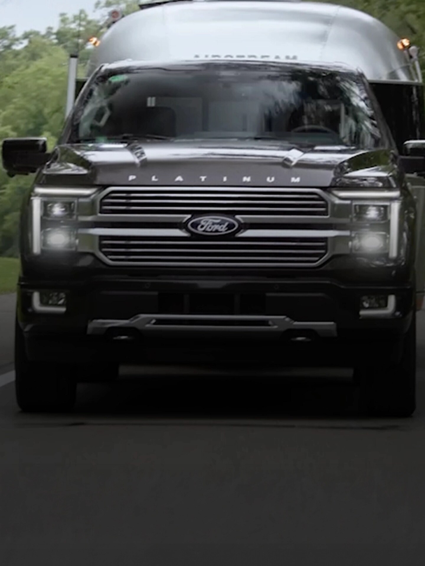 Ford trucks and vans driving on varying terrain.