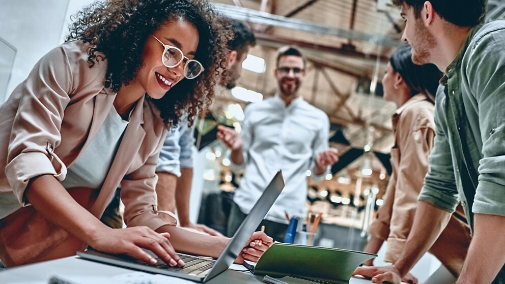 A group of employees work together at a table.