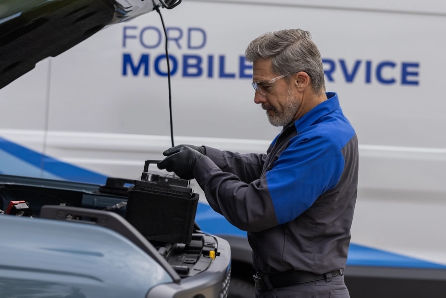 A Ford Service Technician works on a vehicle engine.