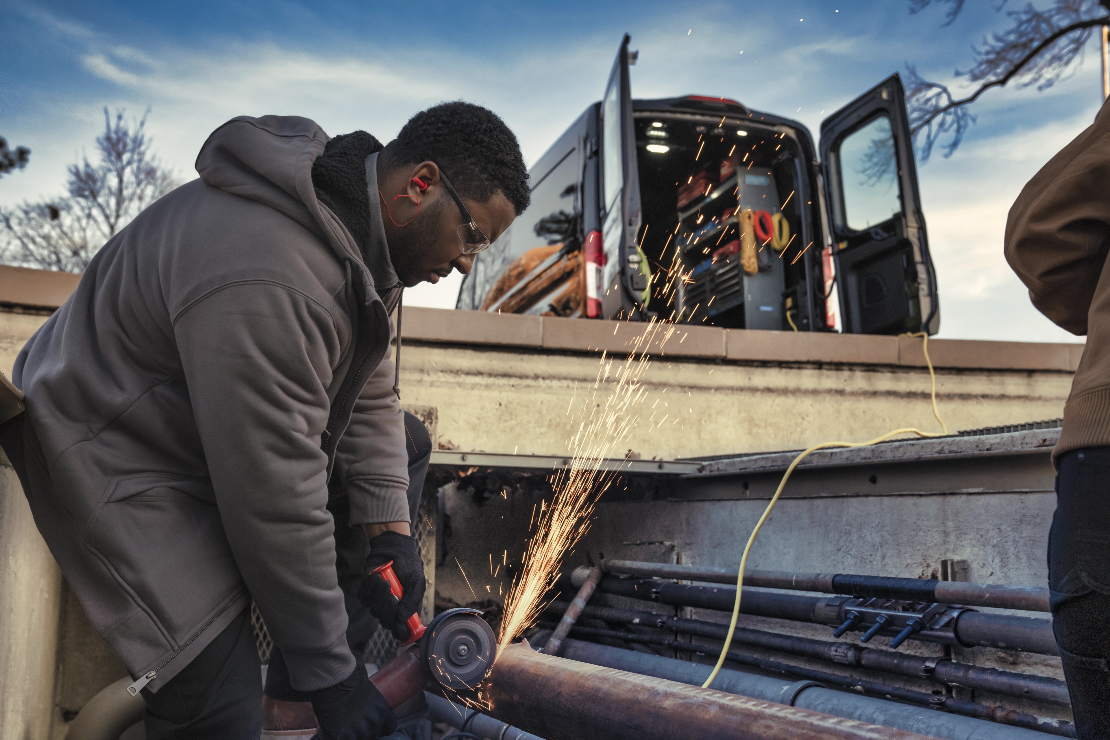 A dark 2025 Ford E-Transit™ van with rear doors open to plug in to Pro Power Onboard™