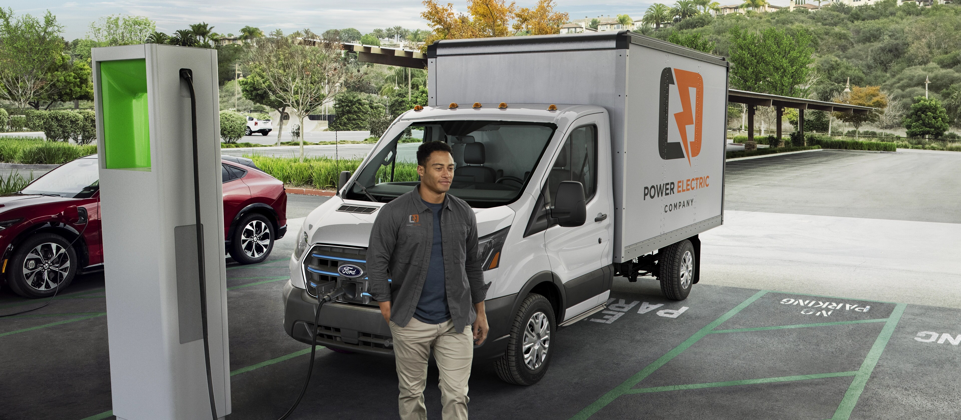 A white 2025 Ford E-Transit™ parked and charging at a public lot