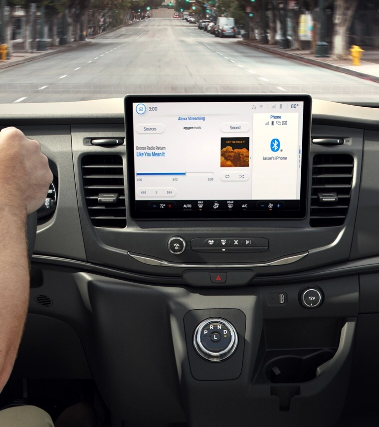 Hands on the wheel next to the dashboard computer display