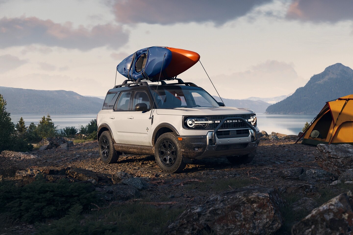 A white Bronco® Sport parked by a camp site.