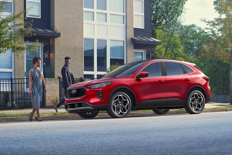 Couple walking up to a Rapid Red 2026 Ford Escape® SUV