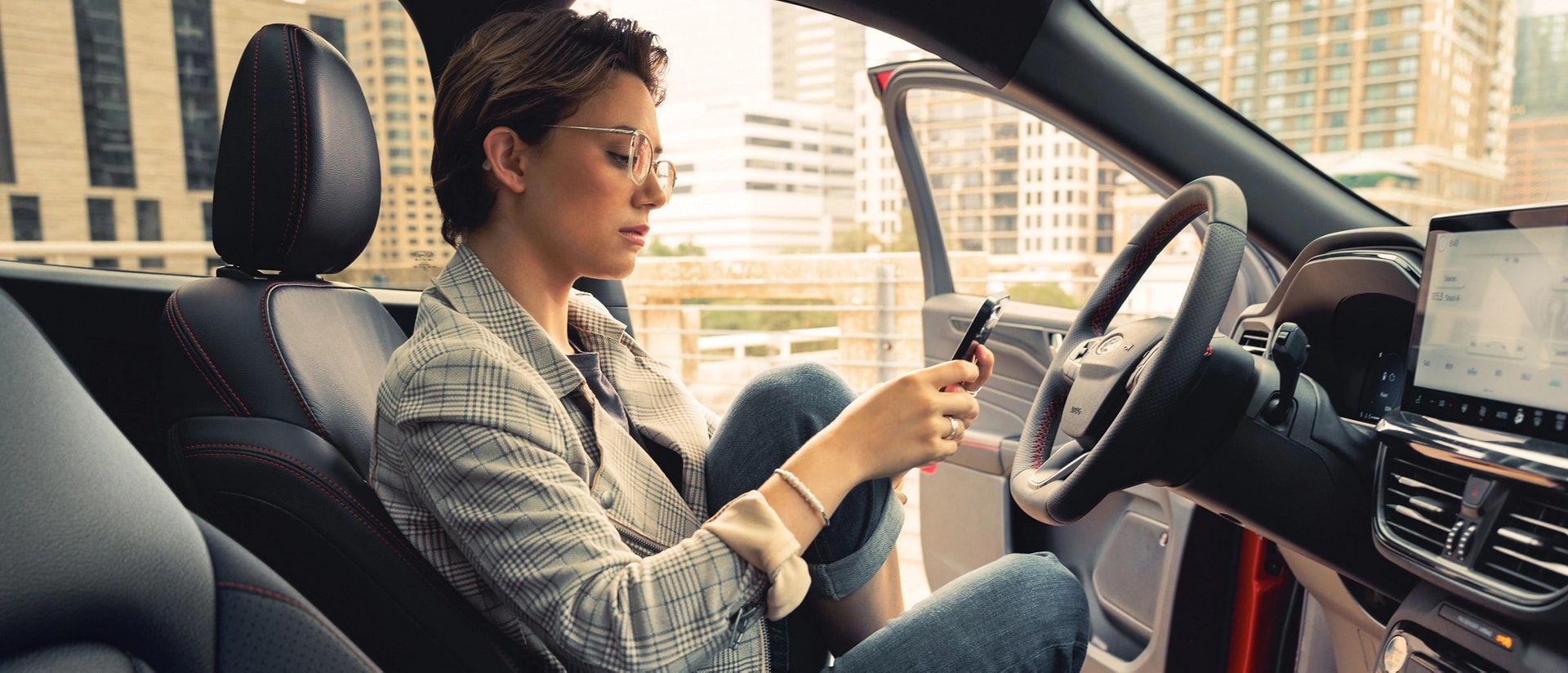 Woman using a phone in a parked 2026 Ford Escape® SUV