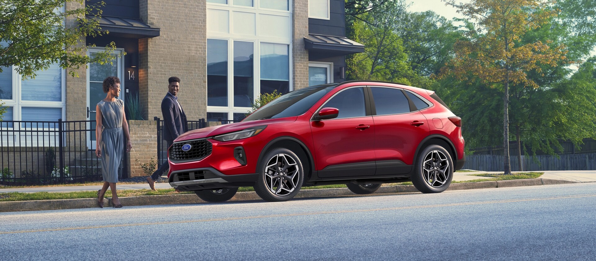 Two people walking up to a 2026 Ford Escape® SUV parked on a city street