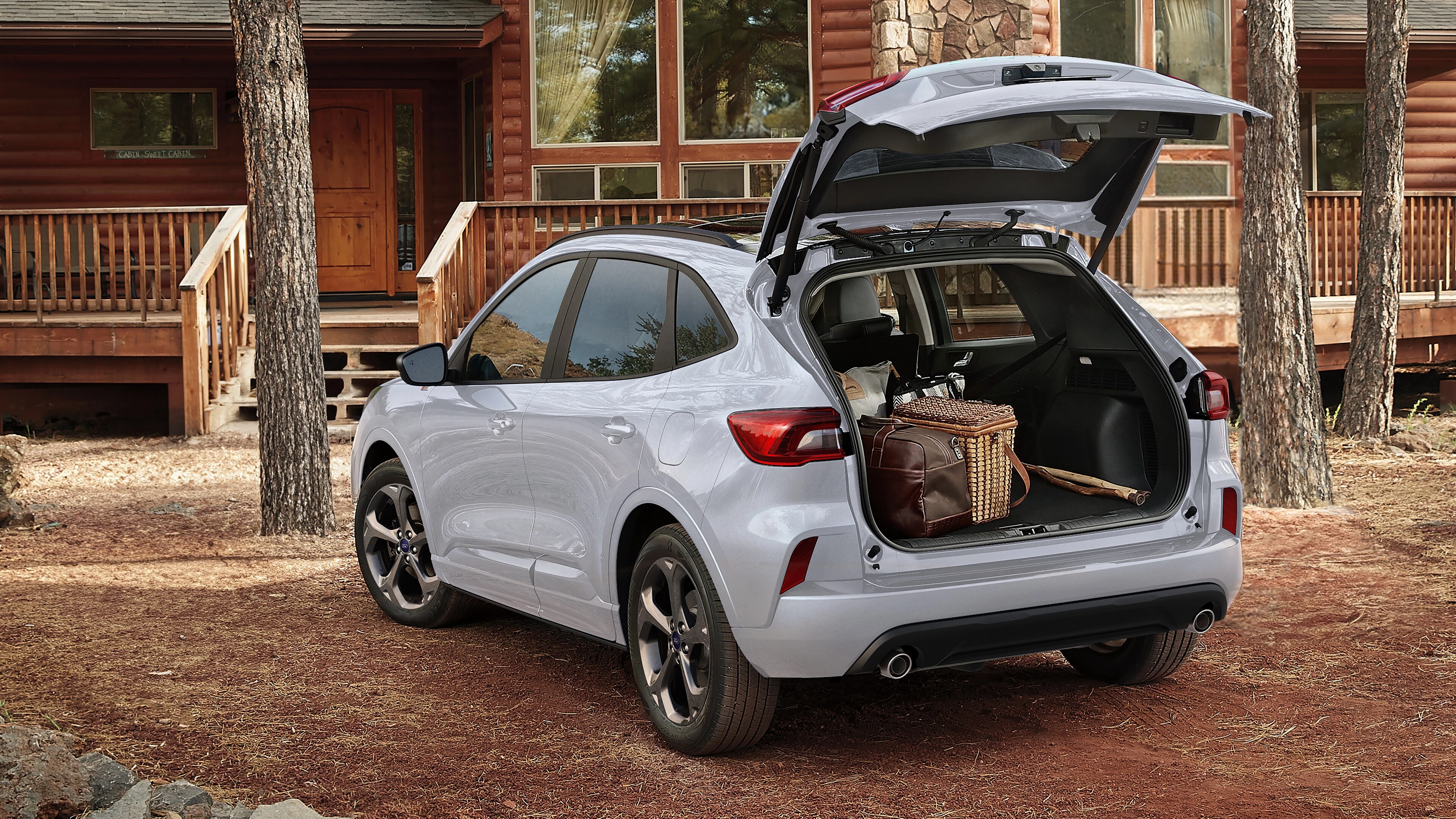 2026 Ford Escape® SUV parked in front of a cabin with the power liftgate open