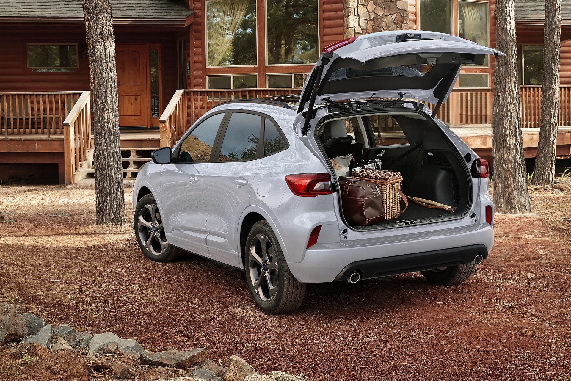 2026 Ford Escape® SUV parked outside a cabin with the power liftgate open