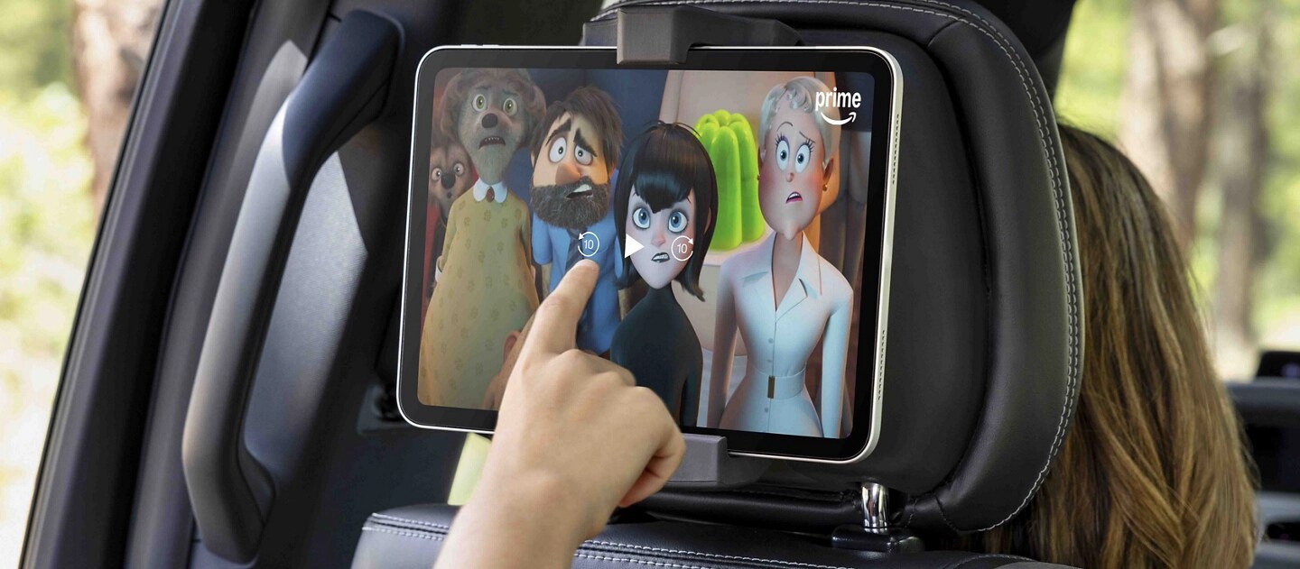 Passenger using a tablet in the available second-row digital device holder in a 2025 Ford Expedition® SUV