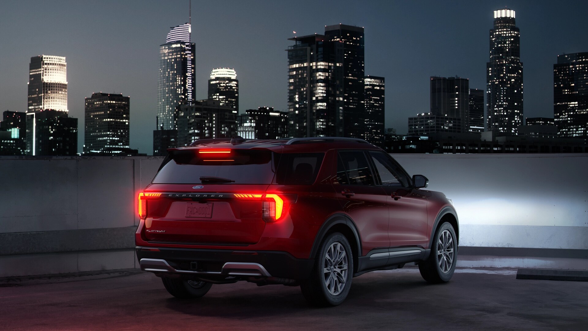 A three-quarters rear view of a 2026 Ford Explorer® SUV with the taillamps illuminated
