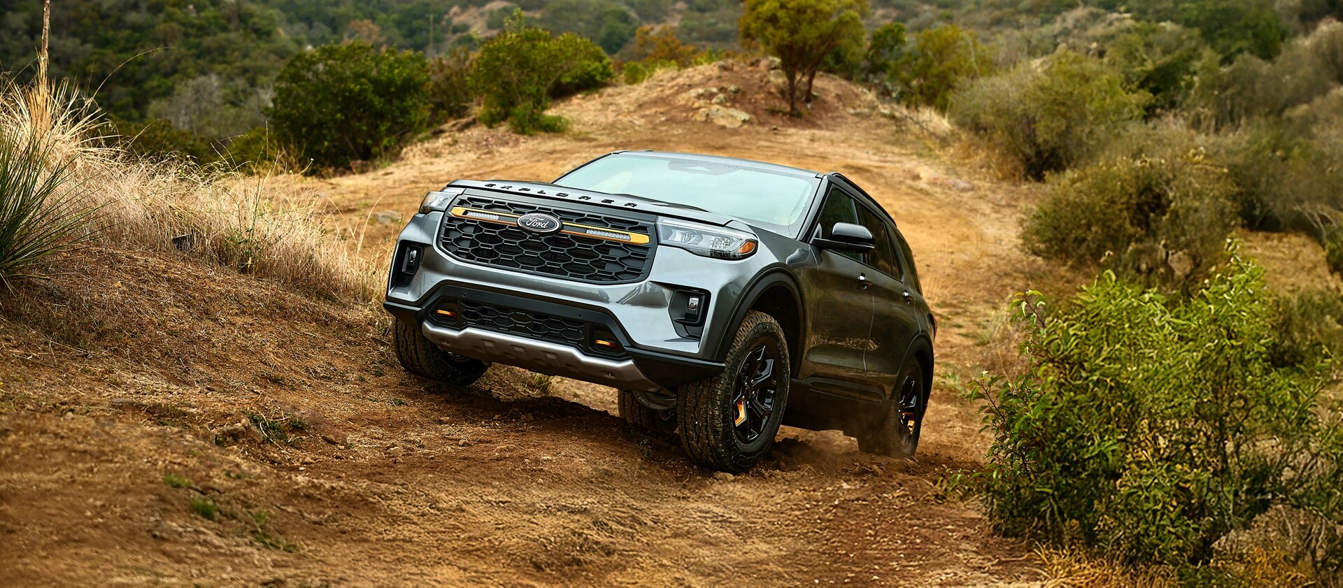 A close-up of the front of a 2026 Ford Explorer® Tremor® SUV parked on a dirt road