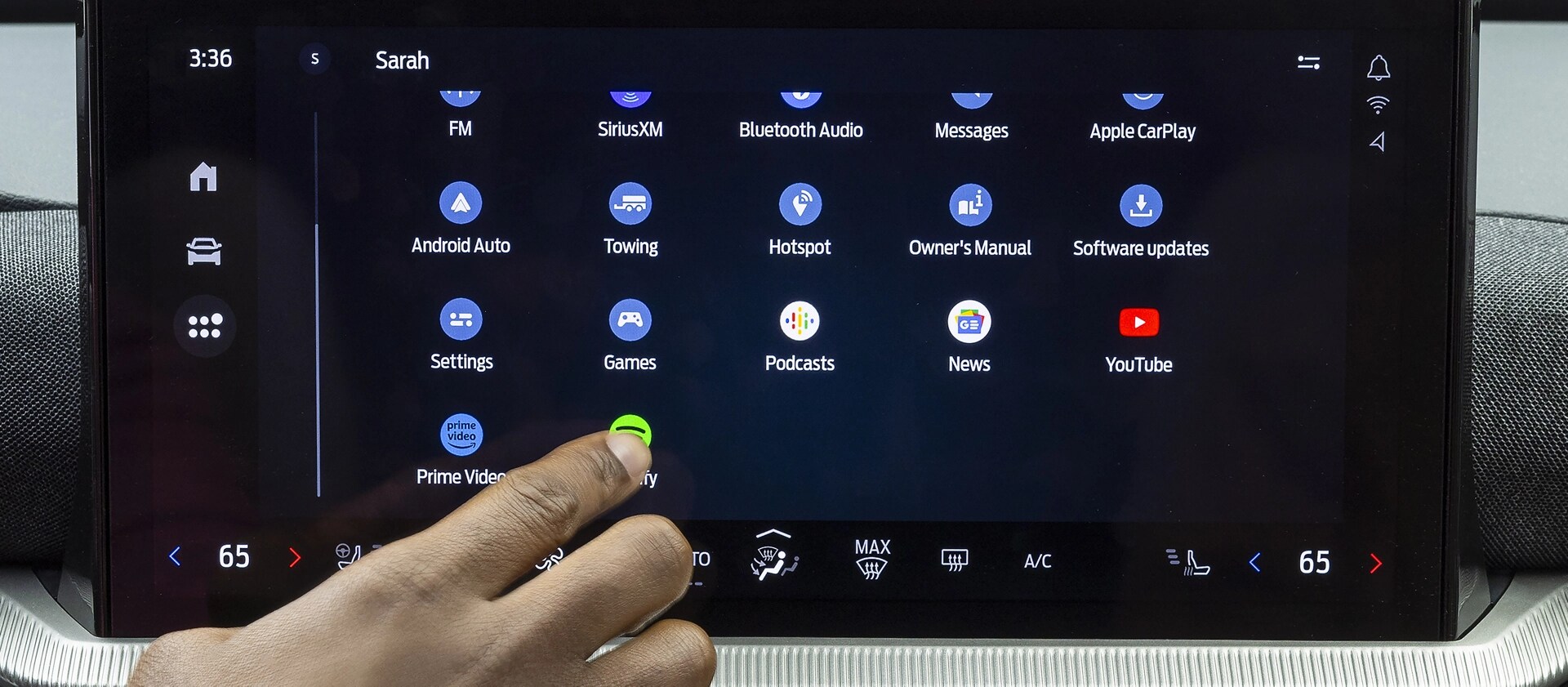 A driver's hand reaching out to touch an icon on the centre display of a 2026 Ford Explorer® SUV