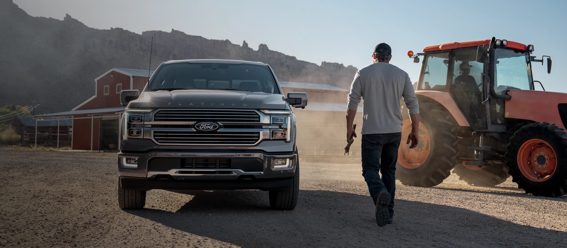 Person walking toward a 2025 Ford F-150 Platinum® pickup parked at a farm