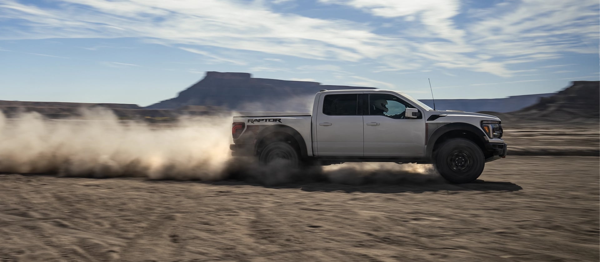 2025 Ford F-150® Raptor® R™ racing across the desert leaving a trail of dust behind