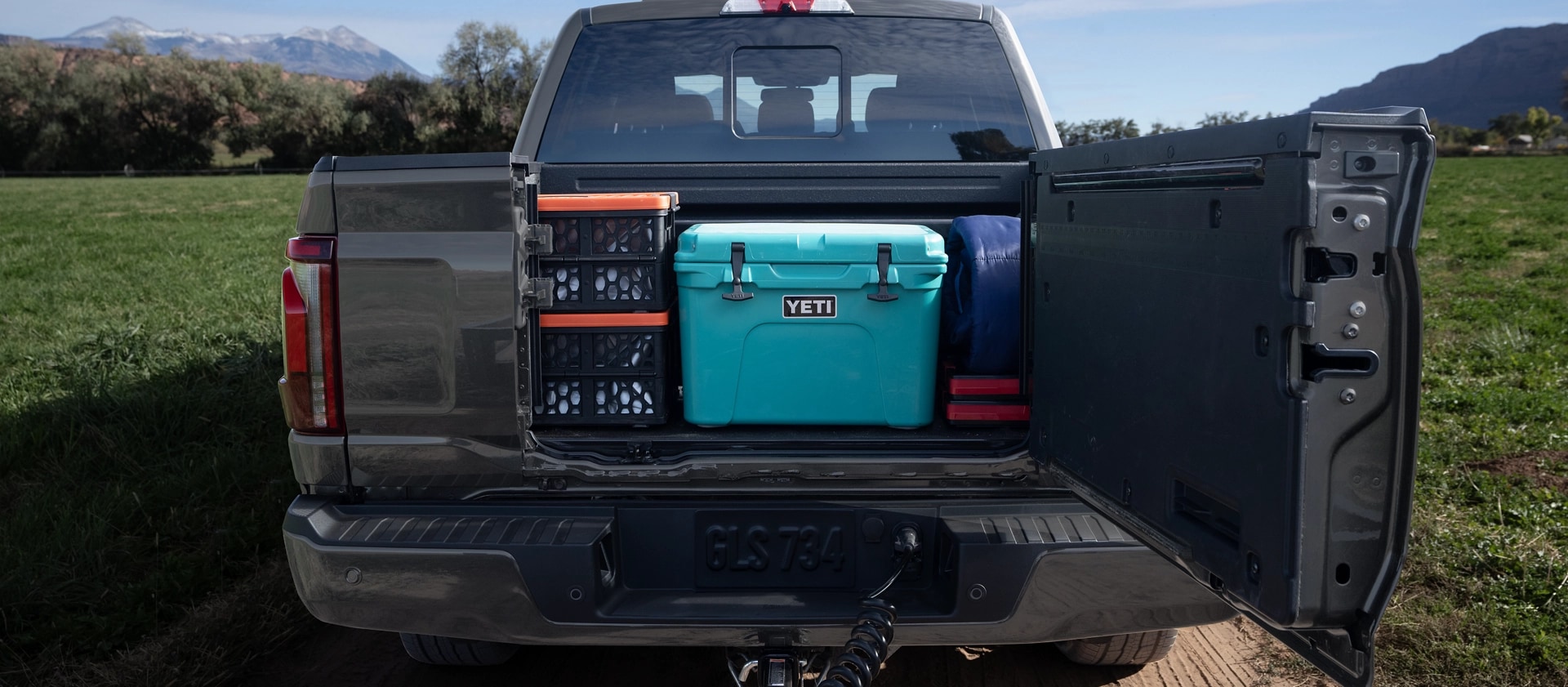Rear view of a 2025 Ford F-150® pickup with the Pro Access Tailgate open showing items in the truck bed