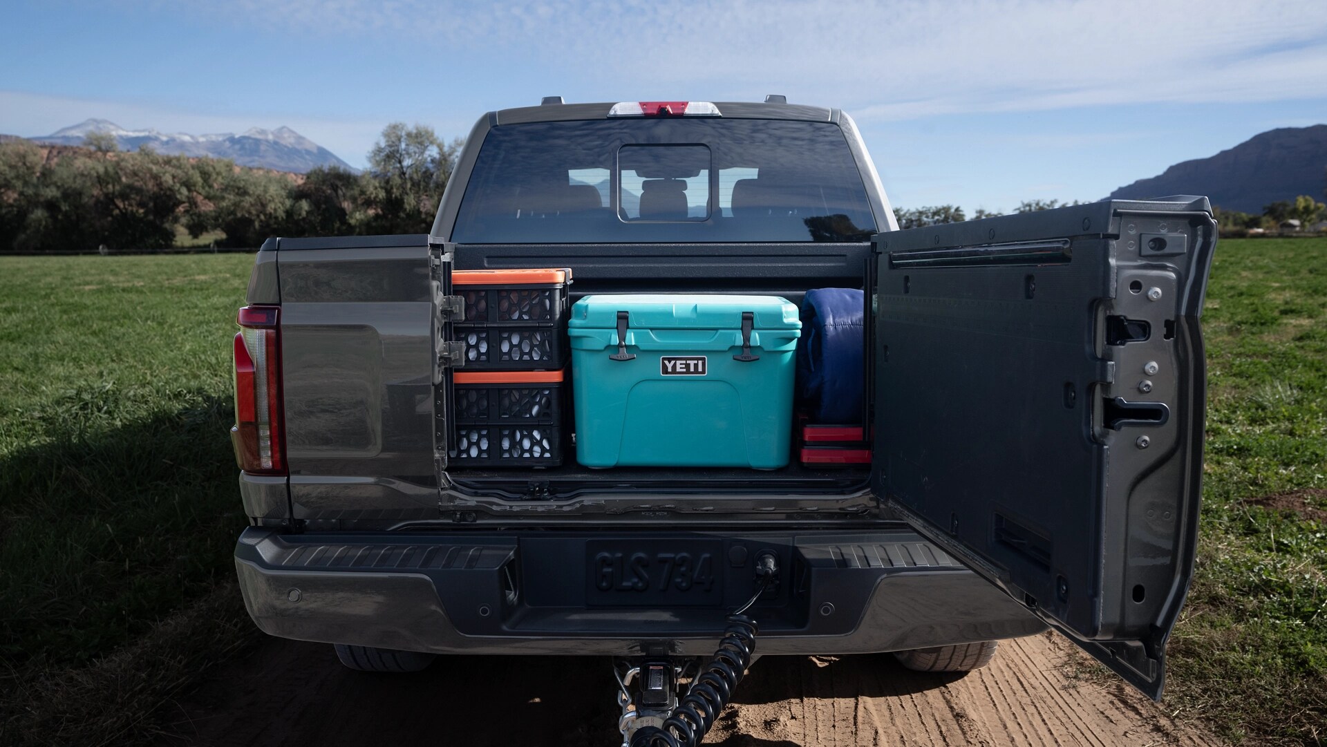 Rear view of a 2025 Ford F-150® pickup with the Pro Access Tailgate open showing items in the truck bed