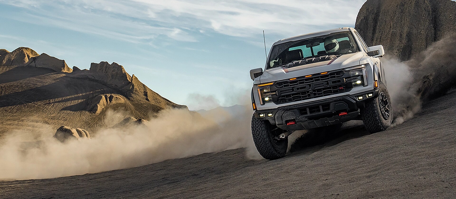 2025 Ford F-150® Raptor® R® racing across the desert leaving a trail of dust behind