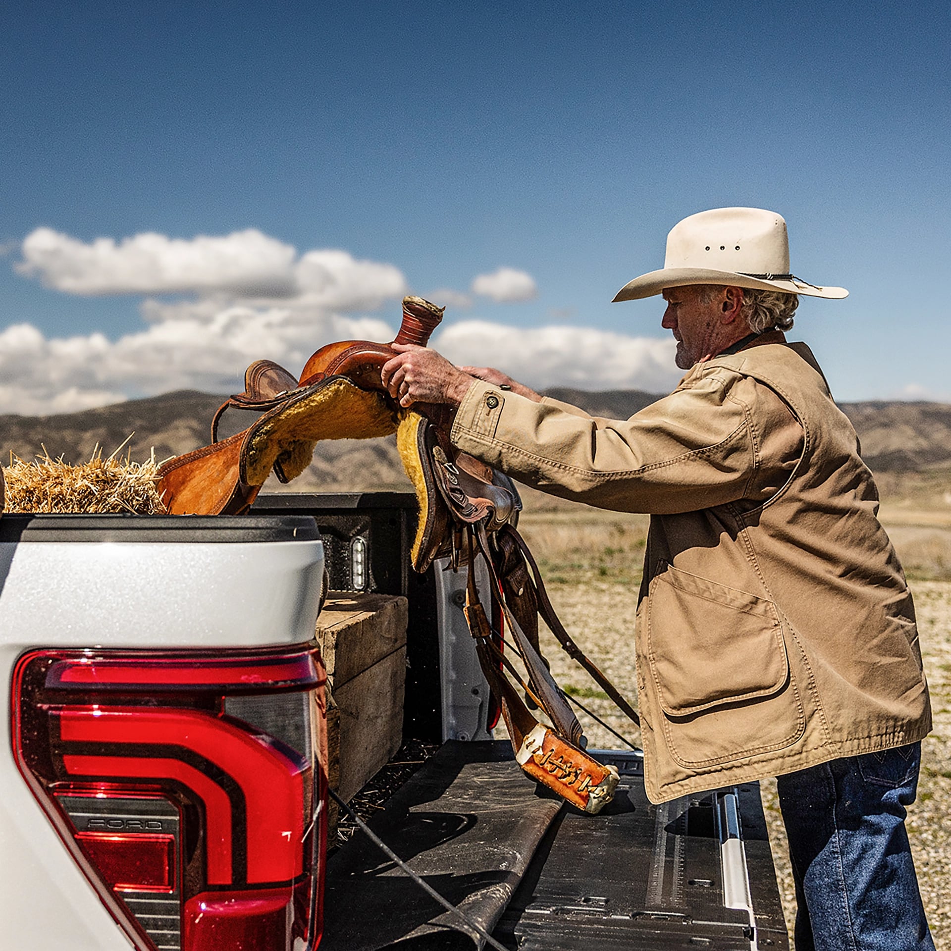 A person unloading a saddle from the bed of their 2025 Ford F-150.
