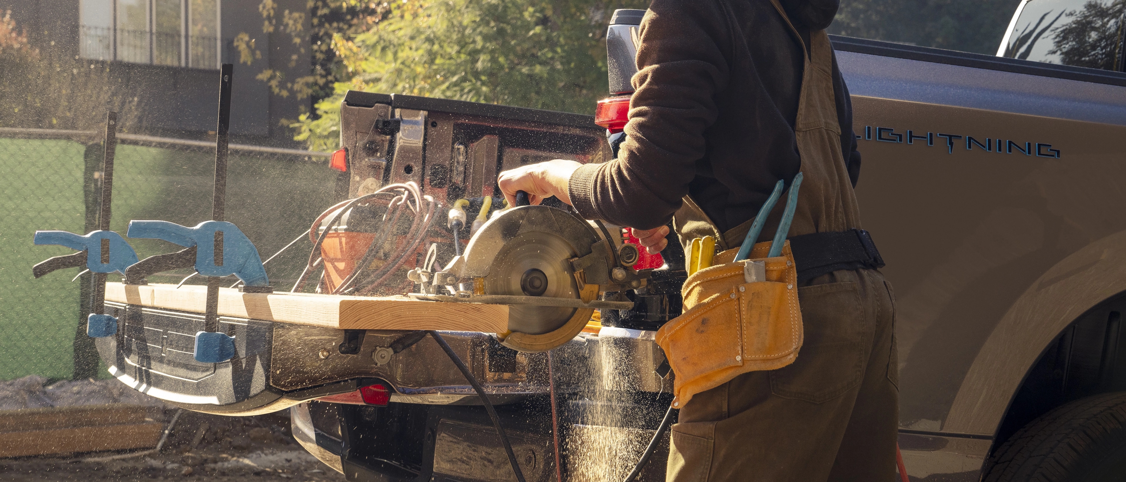 A person with a circular saw being plugged into the Pro Power Onboard™ outlet on a 2025 Ford F-150® Lightning®