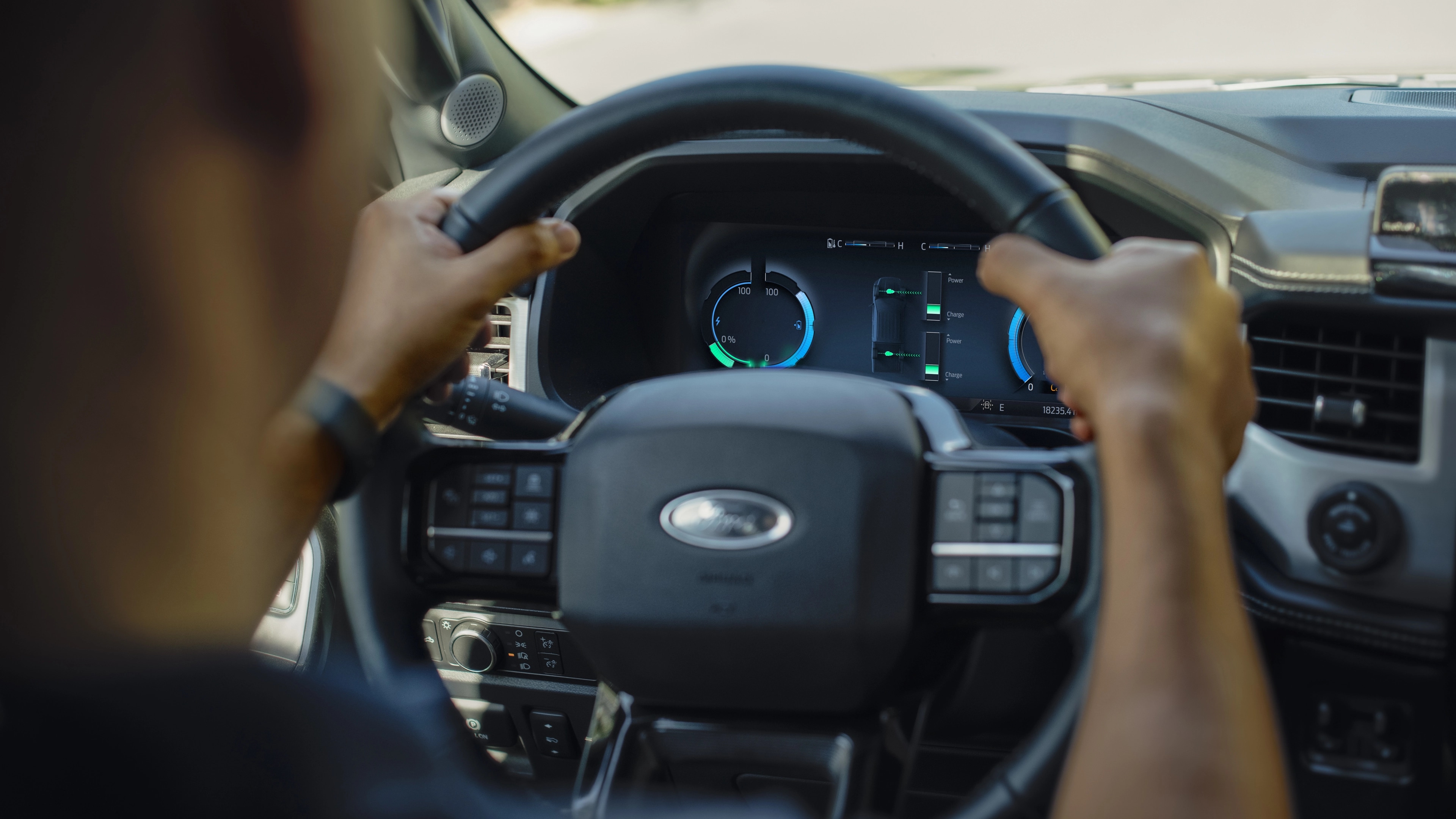 A driver at the wheel of a 2025 Ford F-150® Lightning® pickup