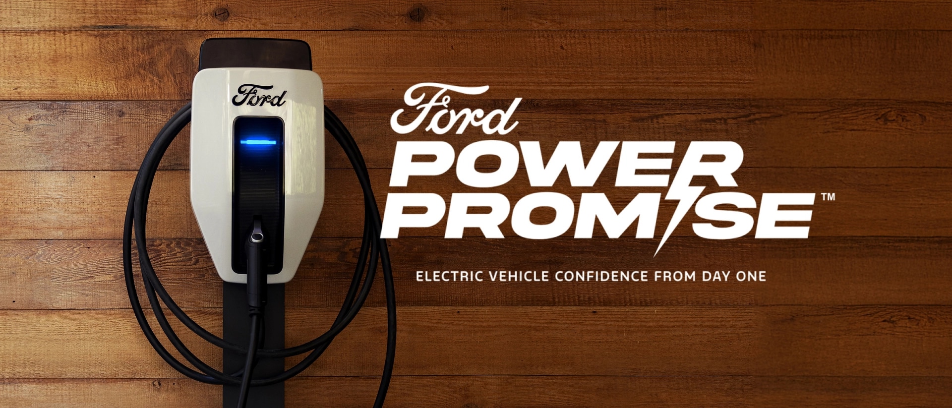 Electric vehicle charger mounted to wall and Power of Promise logo