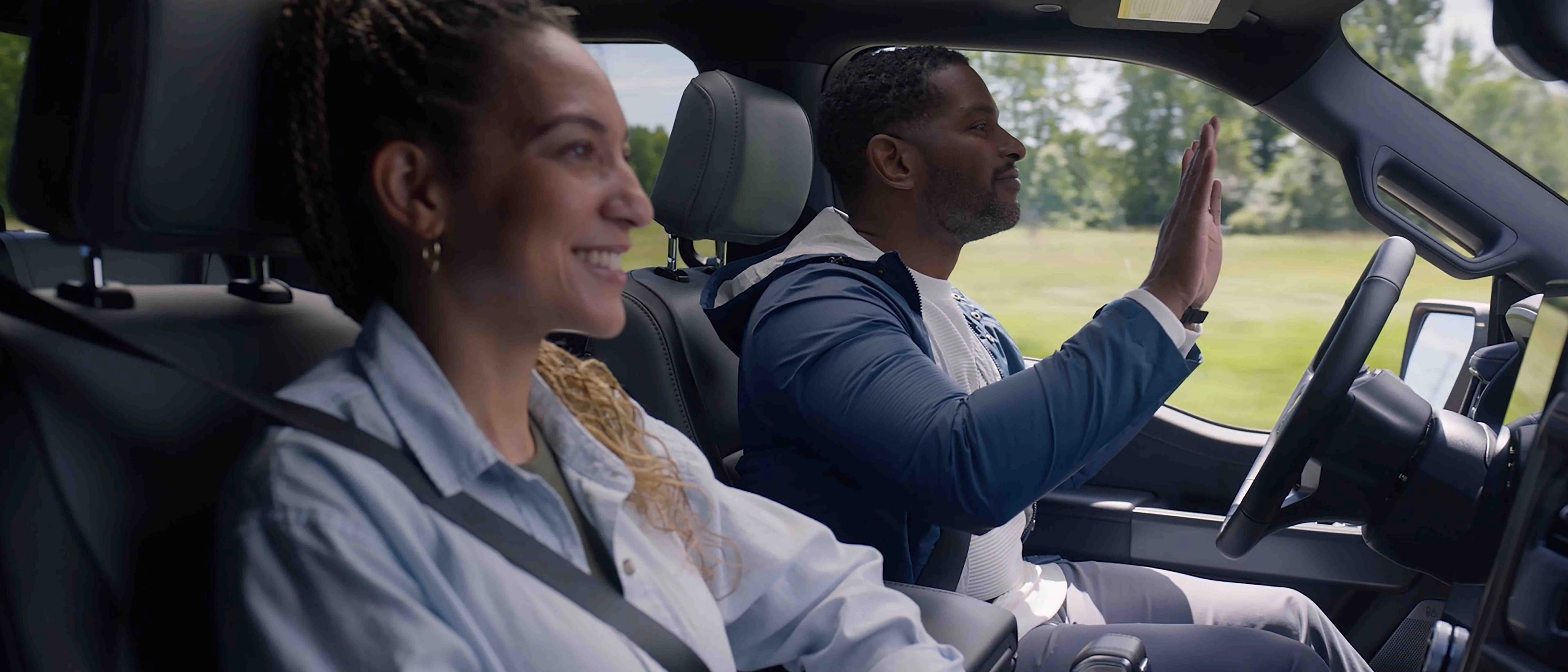 A close-up of two people inside a 2025 Ford F-150® Lightning® engaged with the Ford BlueCruise feature