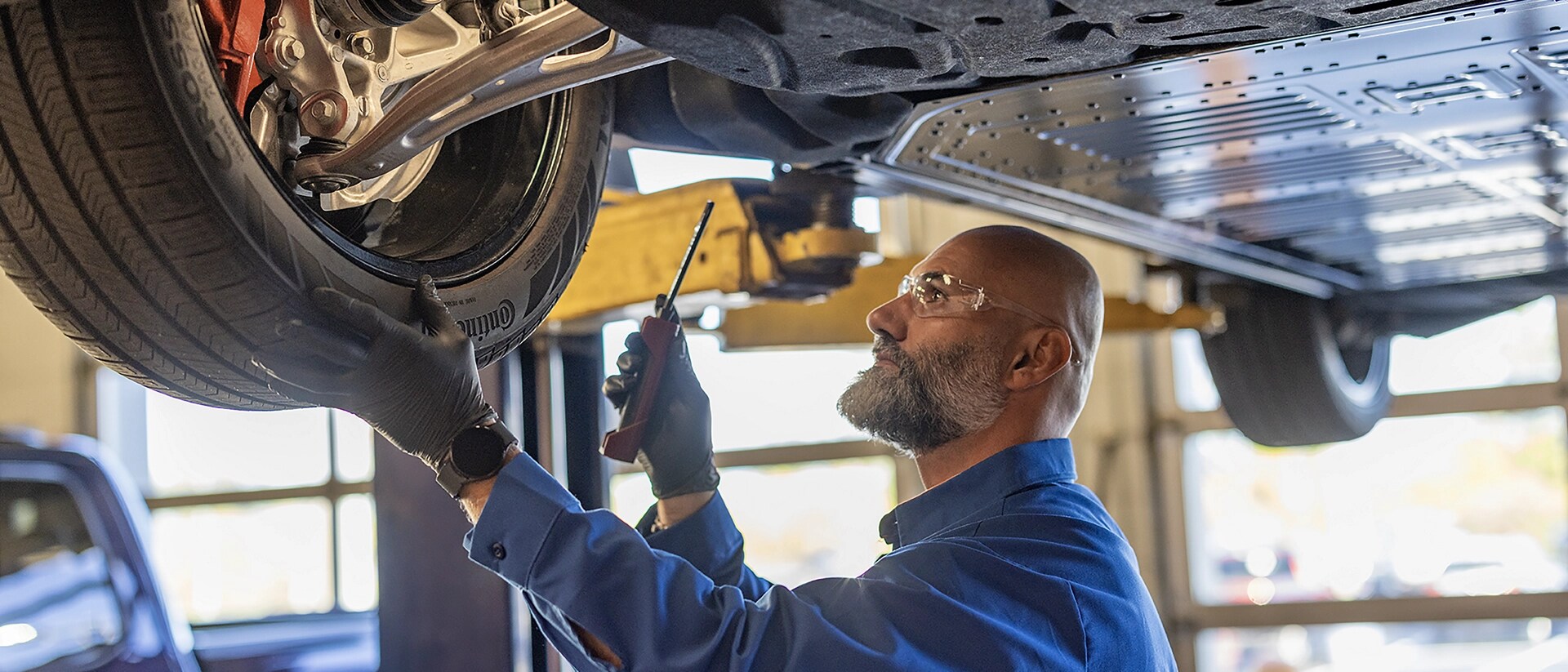 A Ford Service garage with a man performing maintenance on a 2025 Ford Mustang Mach-E®