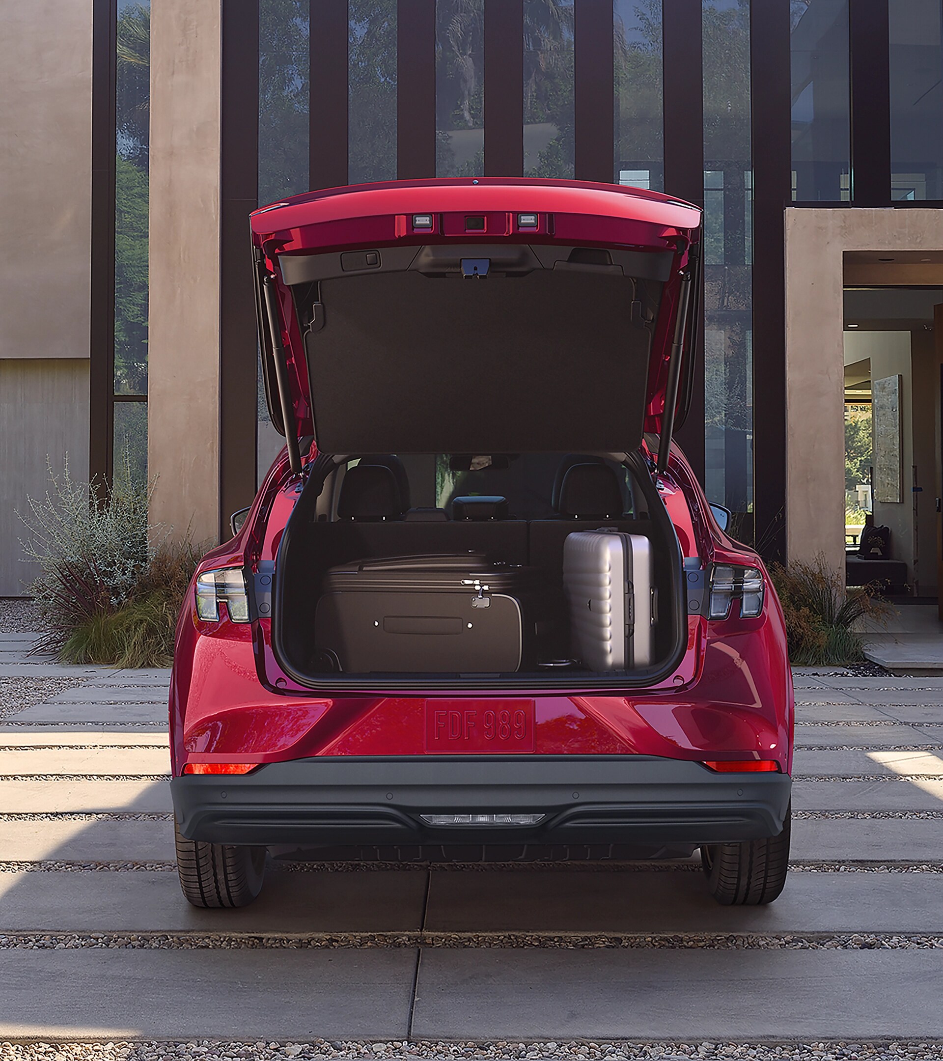 Cargo space of a 2025 Ford Mustang Mach-E® parked in the driveway of a luxury home