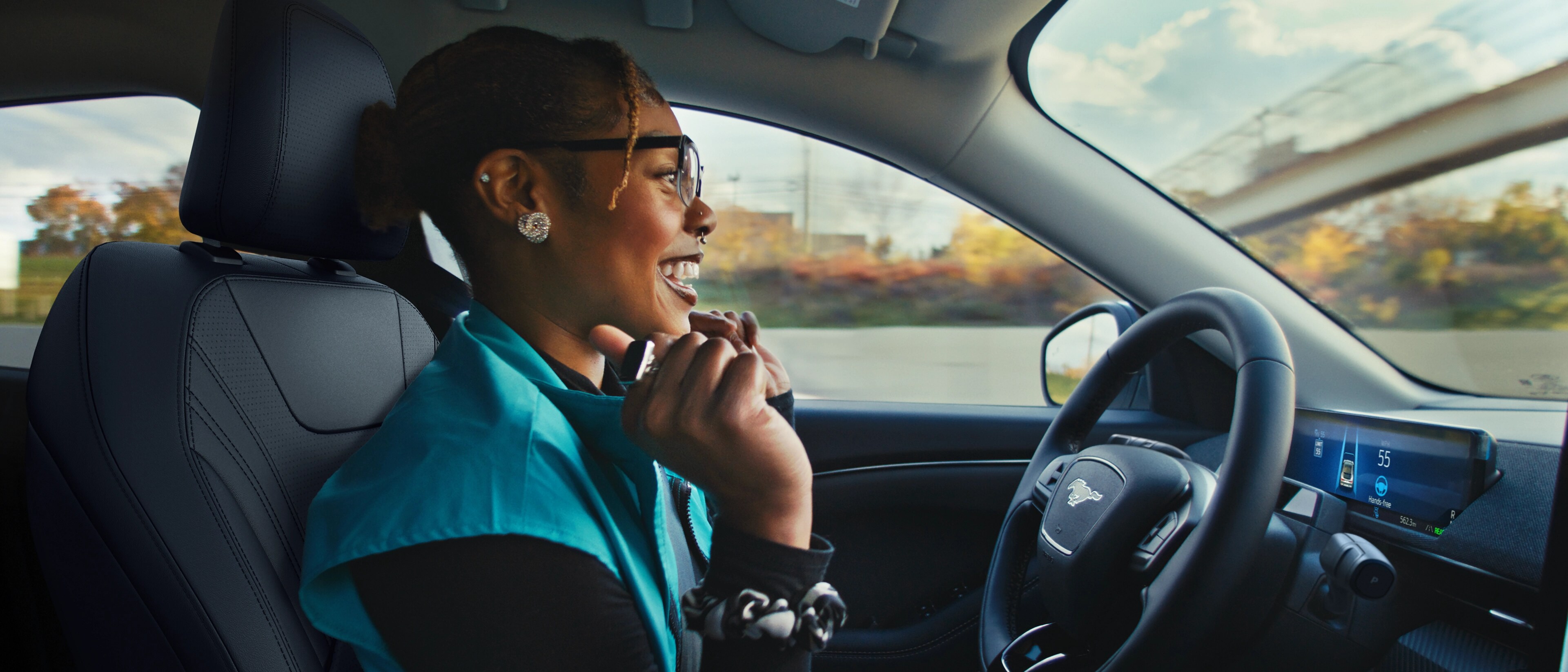 A woman behind the wheel of a 2025 Ford Mustang Mach-E® with her hands off the wheel